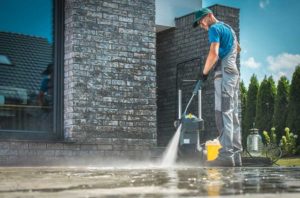 Man using pressure washer after following tips