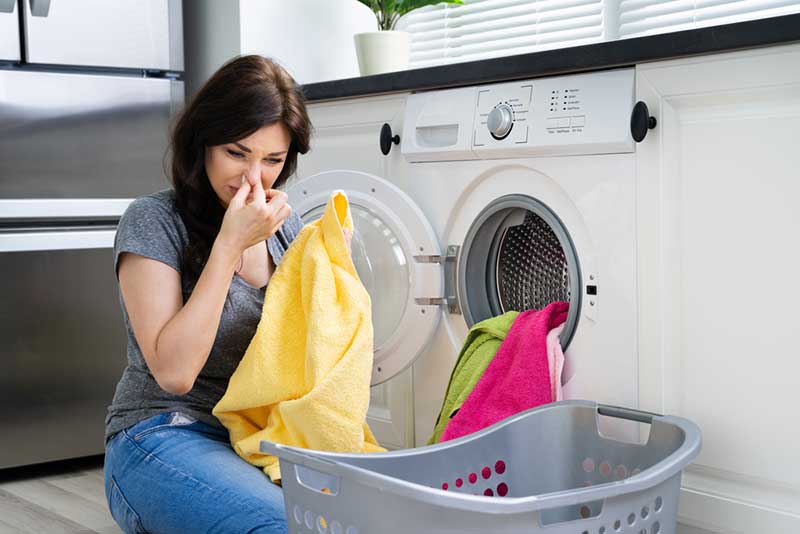 woman next to smelly washing machine