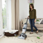 Woman cleaning carpet with carpet cleaner